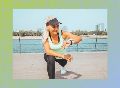 happy woman doing walking lunges, stretching outdoors by the water on sunny day