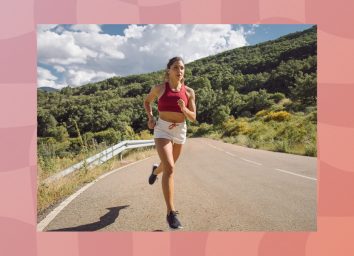 female runner running outdoors on road on sunny day by mountain