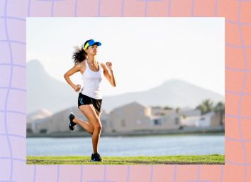 fit, focused female runner running outdoors along lake or body of water at sunset
