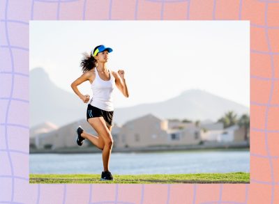 fit, focused female runner running outdoors along lake or body of water at sunset