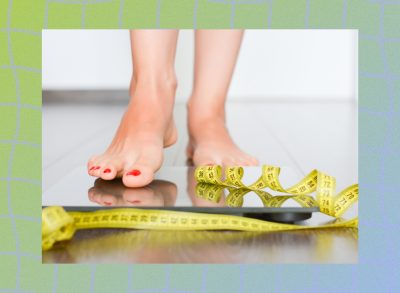 close-up of woman's feet stepping onto scale with measuring tape nearby