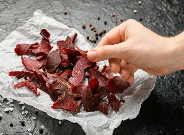 hand reaching for a piece of beef jerky