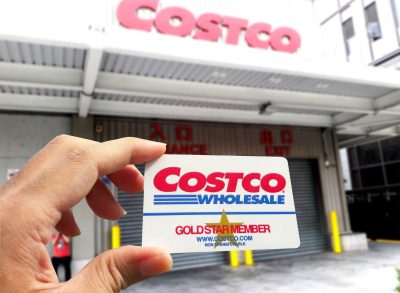 Costco membership card help up in front of warehouse