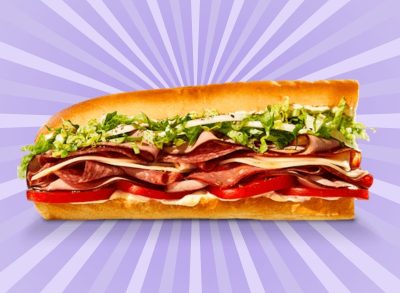 The Italian Night Club sandwich from Jimmy John's restaurant, set against a vibrant purple background.