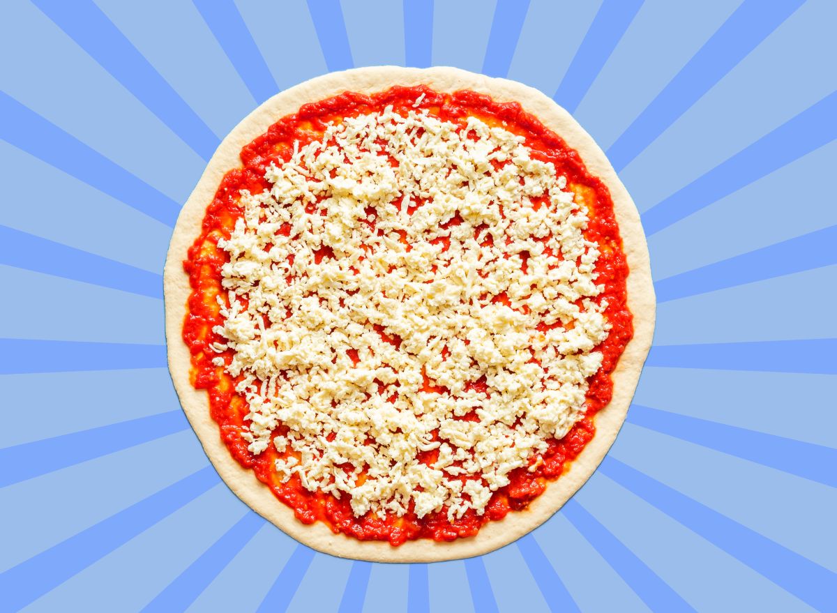 Pizza dough with tomato sauce and mozzarella set against a vibrant blue background.