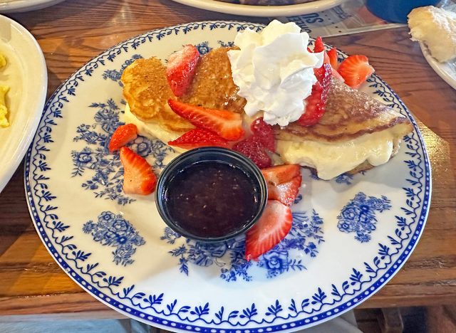 Two Buttermilk Pancakes layered with cream cheese cheesecake filling, topped with Fresh Strawberries, powdered sugar and Strawberry Syrup at Cracker Barrel