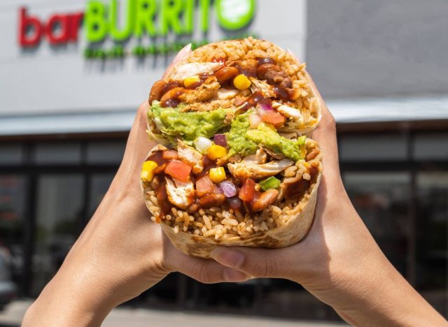 Burrito from Burritobar being held up in front of a storefront