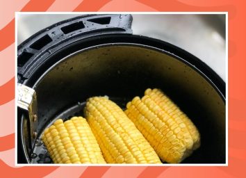corn inside an air fryer on a red background