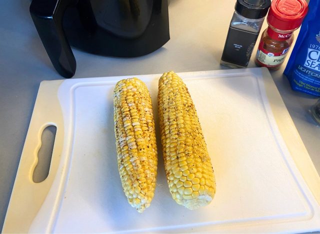 seasoned corn on the cob on a cutting board