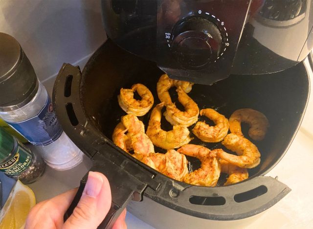 cooked shrimp inside of an air fryer basket