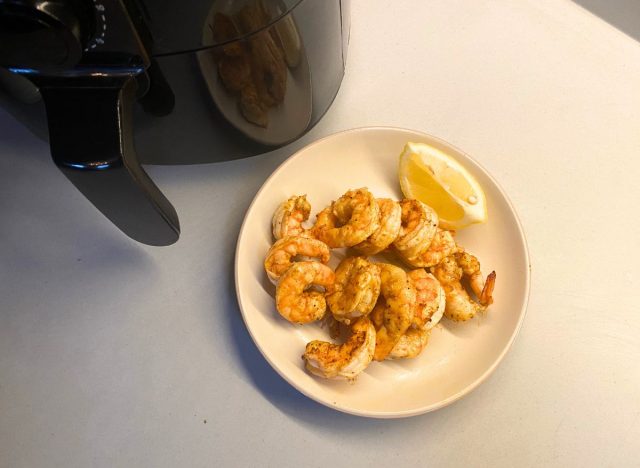 cooked shrimp on a plate with a lemon wedge