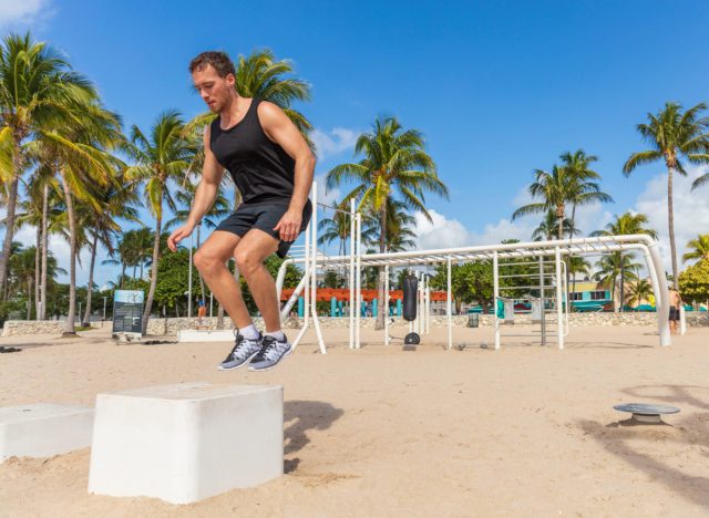 fit man doing box jumps at the beach