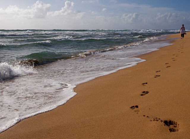 waves at the beach and footprints in the sand