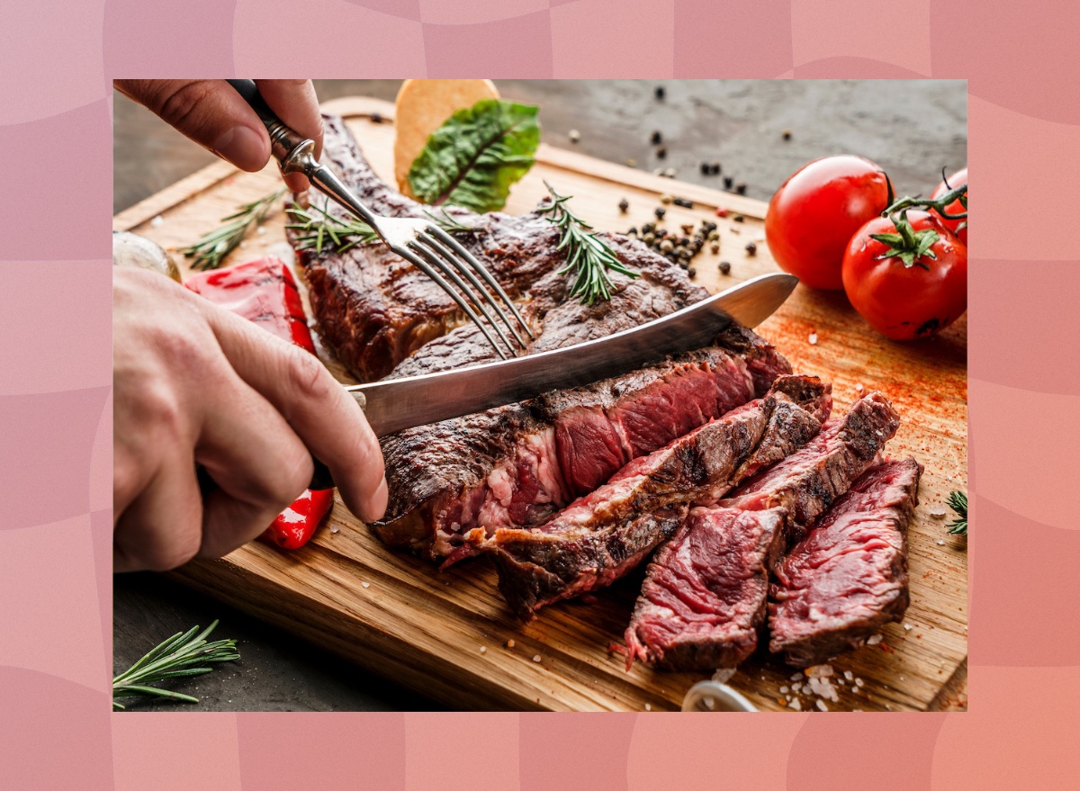 close-up of man's hands cutting steak on cutting board