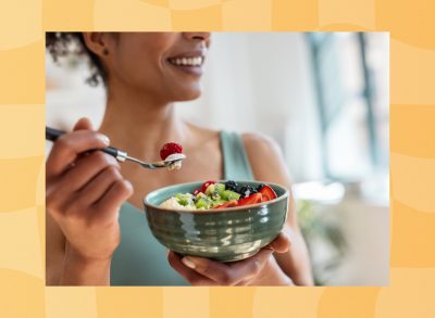 close-up of woman eating healthy yogurt bowl with fruit