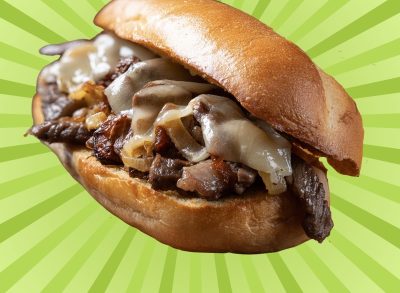 A classic cheesesteak sandwich on a graphic background