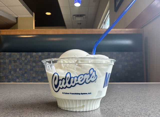 a plastic bowl of vanilla custard from culver's on a booth table 