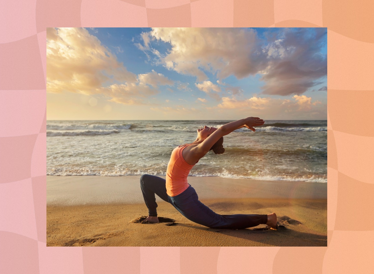 woman doing low or crescent lunge on the sand at the beach at sunset