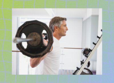 fit, mature man doing barbell back squats in bright gym