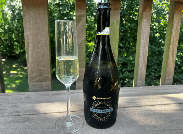 members mark prosecco bottle next to a glass on outdoor table