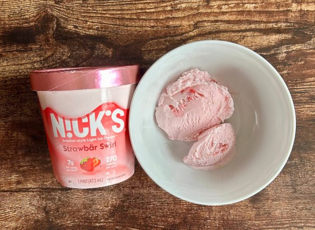 pint of nicks strawbär swirl light ice cream next to a bowl of the ice cream