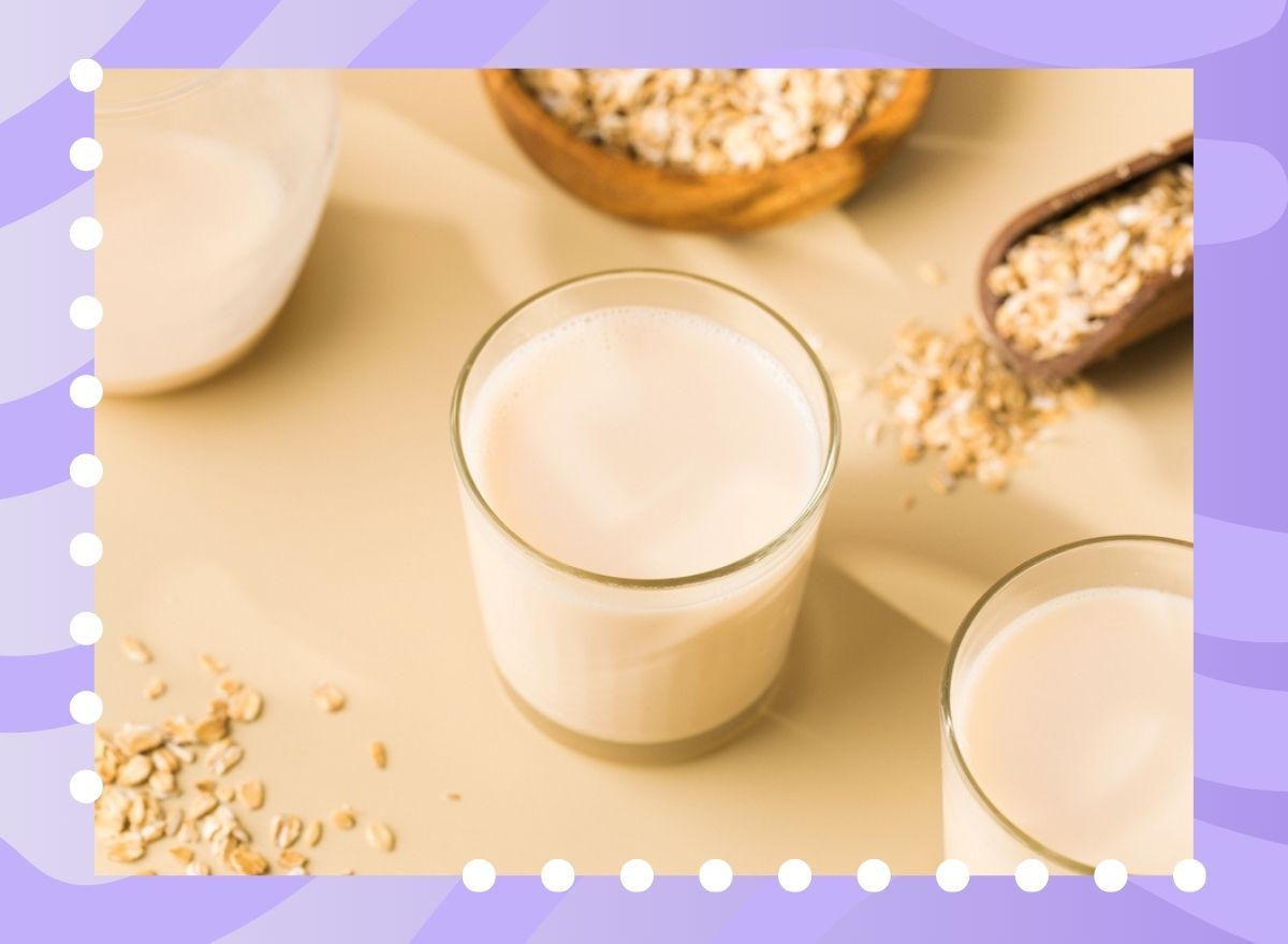 glass of oat milk on a table with a purple background