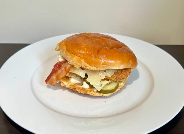 popeyes' bacon and cheese chicken sandwich on a white plate