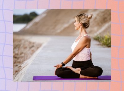 woman doing spinal twist on yoga mat outdoors