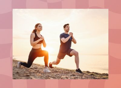 fit couple doing walking lunges on the beach at sunset