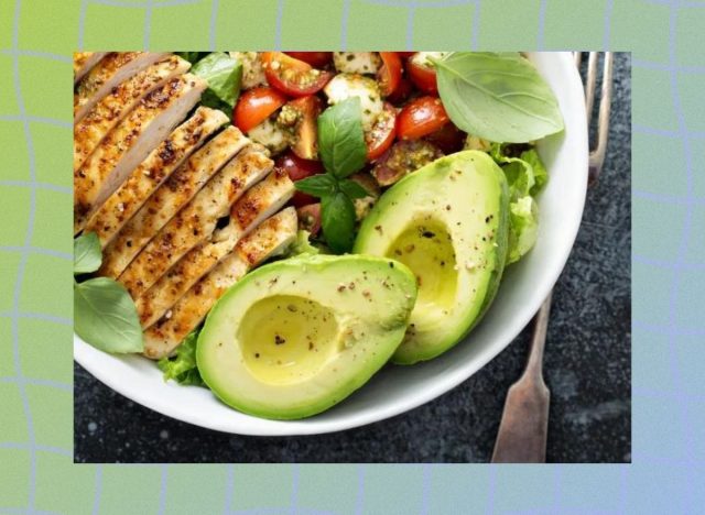 a photo of a healthy salad with grilled chicken and avocados on a designed blue and green background