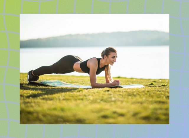 woman holding plank outside on yoga mat