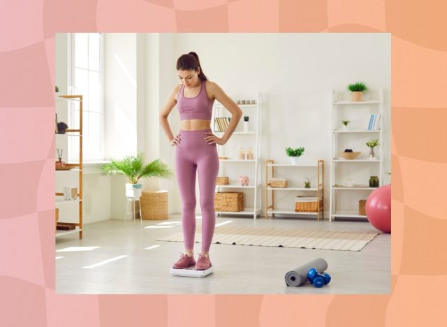 woman stepping on scale and looking at her weight