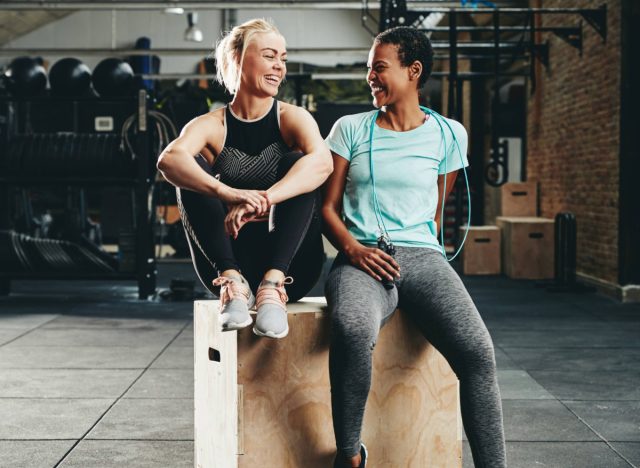 two friends taking a break at the gym, laughing