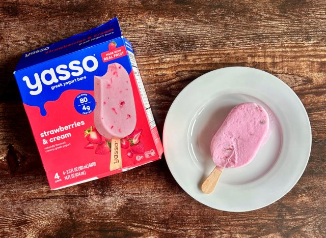 a box of yasso strawberries & cream greek yogurt bars next to a plate with a greek yogurt bar