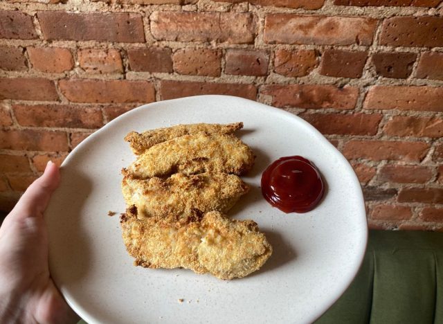 chicken tenders on a plate with ketchup 