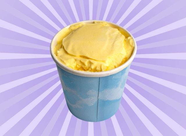 A pint of mango flavored ice cream set against a vibrant purple background