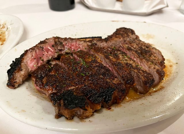 A sliced bone-in New York strip on a white plate at Ruth's Chris Steak House