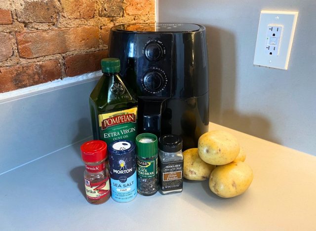 potatoes, oil, and seasonings in front of an air fryer