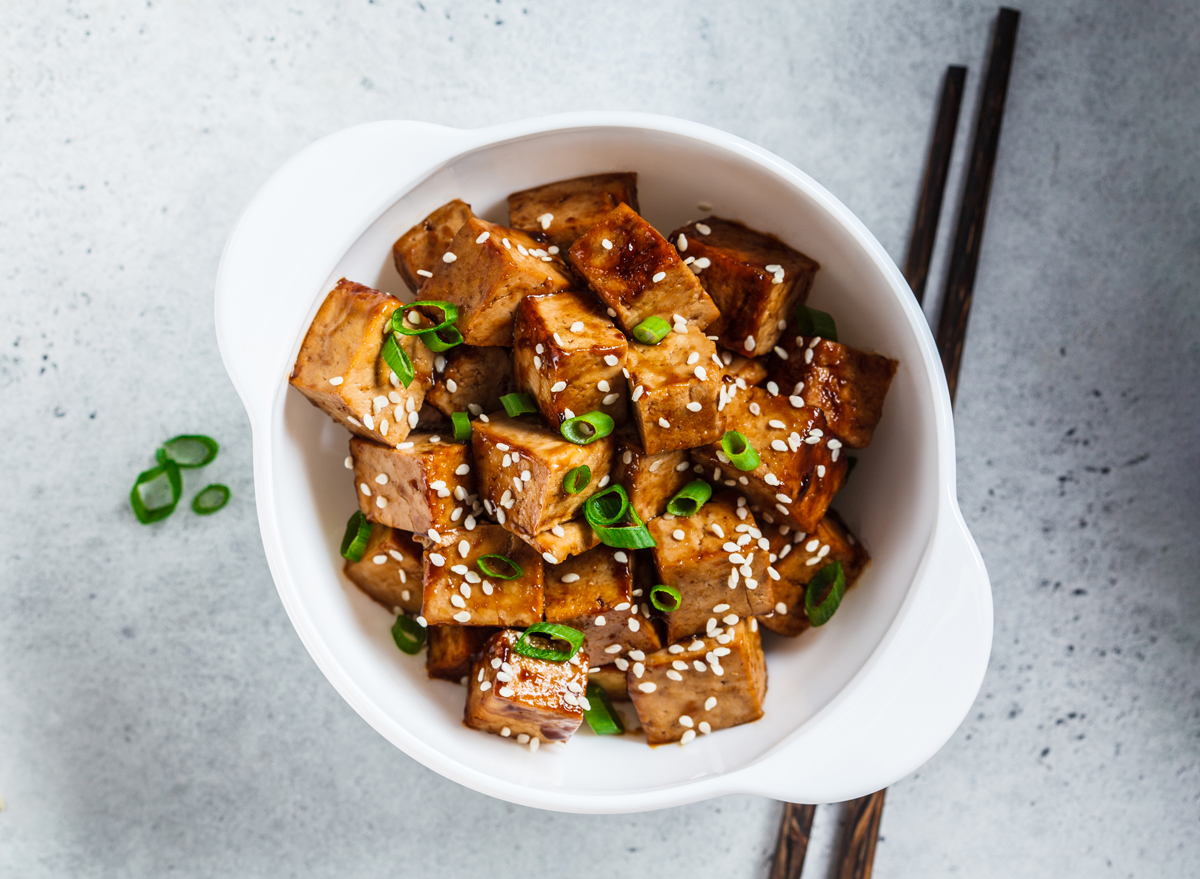 bowl of air fryer teriyaki tofu topped with scallions and sesame seeds