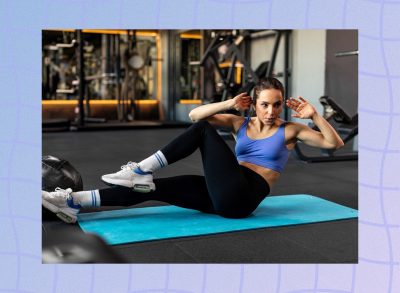 fit woman doing bicycle crunches on workout mat at the gym