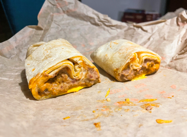 cheesy bean and rice burrito from taco bell cut open on a wrapper