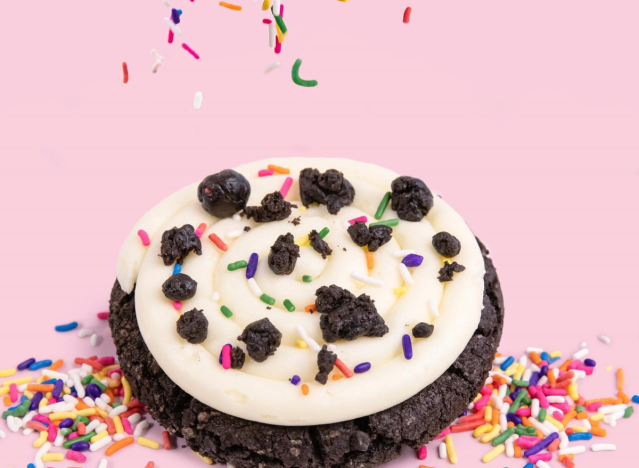 crumbl oreo birthday cake cookie with sprinkles and pink background