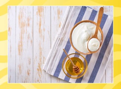 bowl of yogurt and bowl of honey on a table with a yellow background