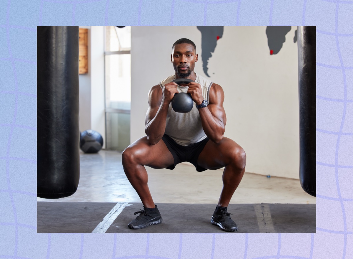 muscular man doing kettlebell squat at the gym