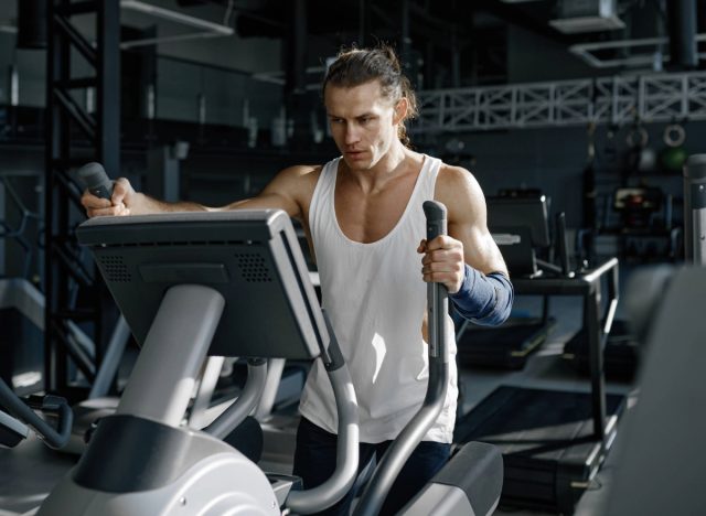 fit man using elliptical trainer