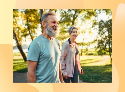 happy, mature couple walking outdoors for exercise on sunny day in park