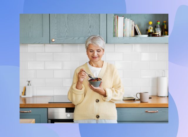 mature, happy woman eating healthy cereal in bright kitchen