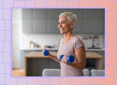 mature, happy woman lifting dumbbells in her living room