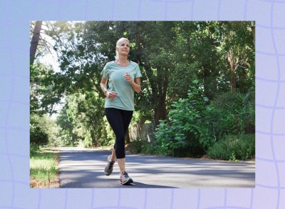 mature woman running outdoors on path surrounded by foliage and green trees