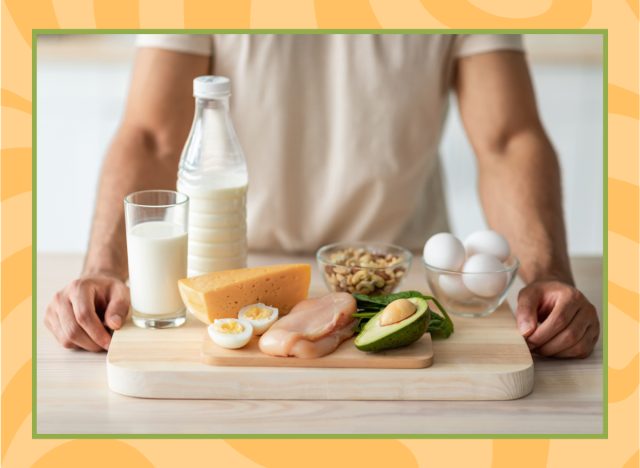 man standing behind a wooden board full of high protein foods